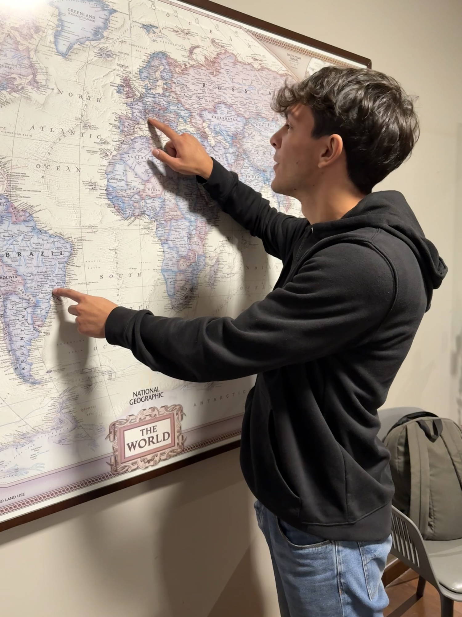 Simone Titotto indica il mondo su una mappa National Geographic